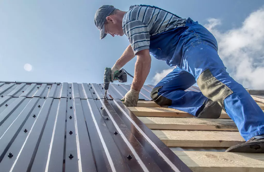 A Worker Installing Metal Roofing Sheets on a Roof
